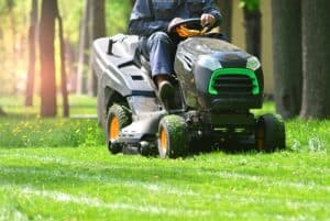 Professional Lawn Mower With Worker Cutting The Grass